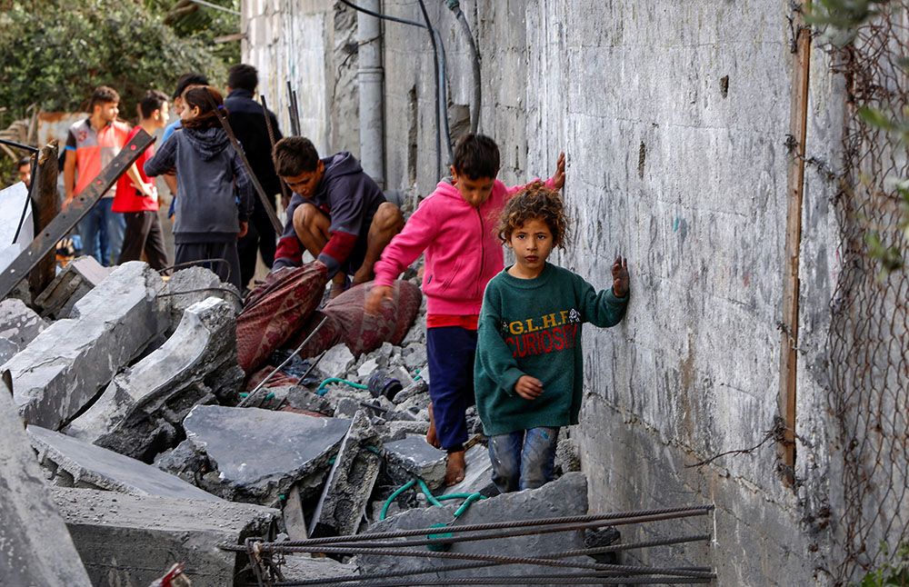 A group of survivors navigate rubble in Gaza.