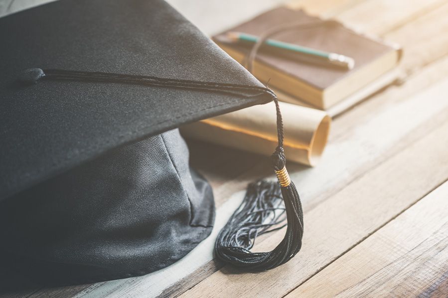 graduation cap and diploma on table