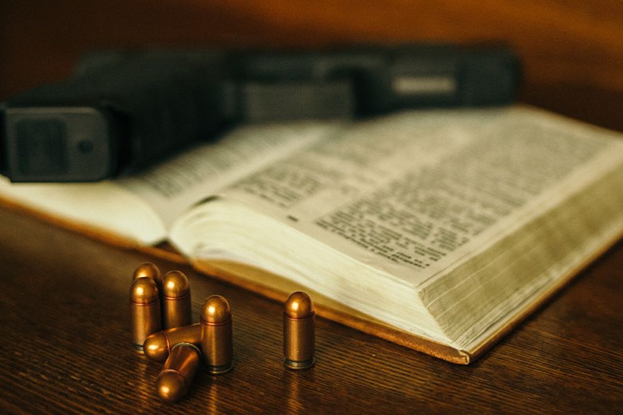 handgun and ammo laying on open bible
