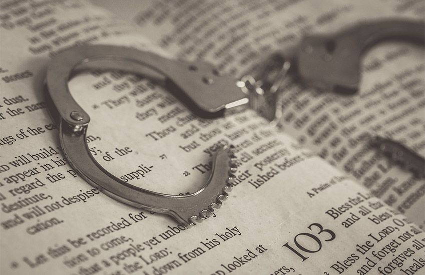 Handcuffs Resting on Top of Bible