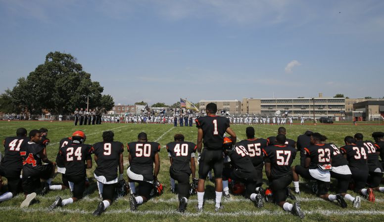 High school football players kneel during the national anthem.