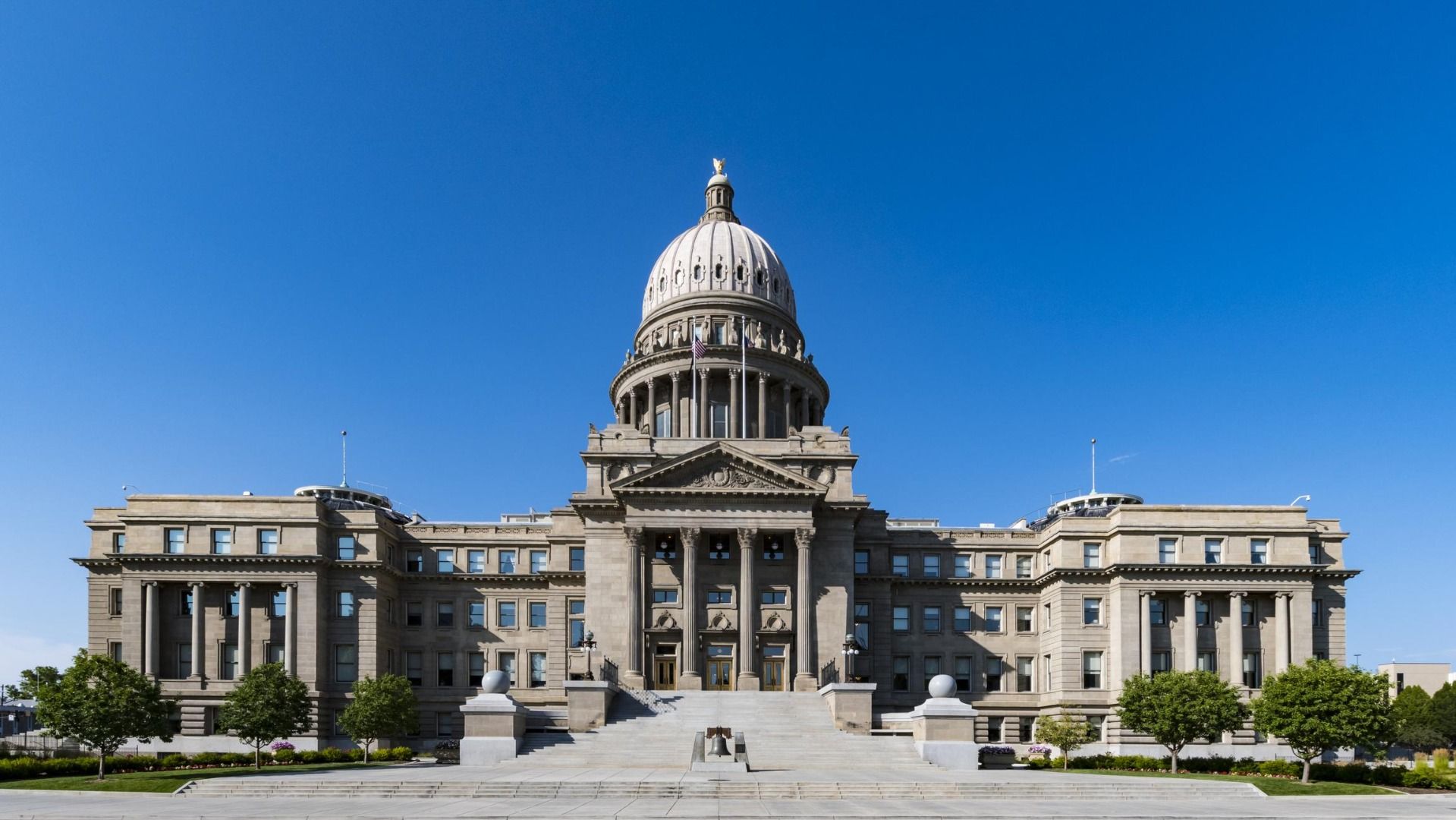 Idaho State Capitol building in Boise under a clear blue sky.