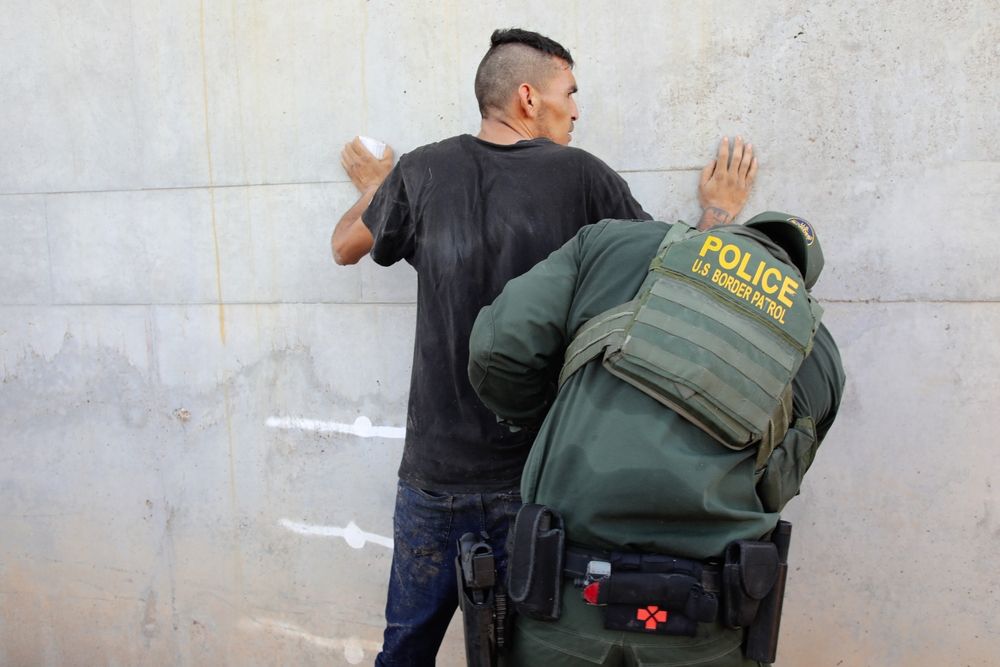 An immigration officer searching a migrant