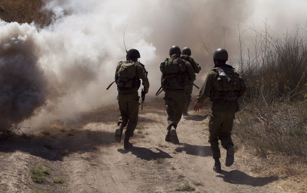 Israeli soldiers running on a road