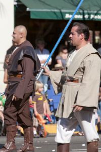 two men dressed as Jedi walking through a parade