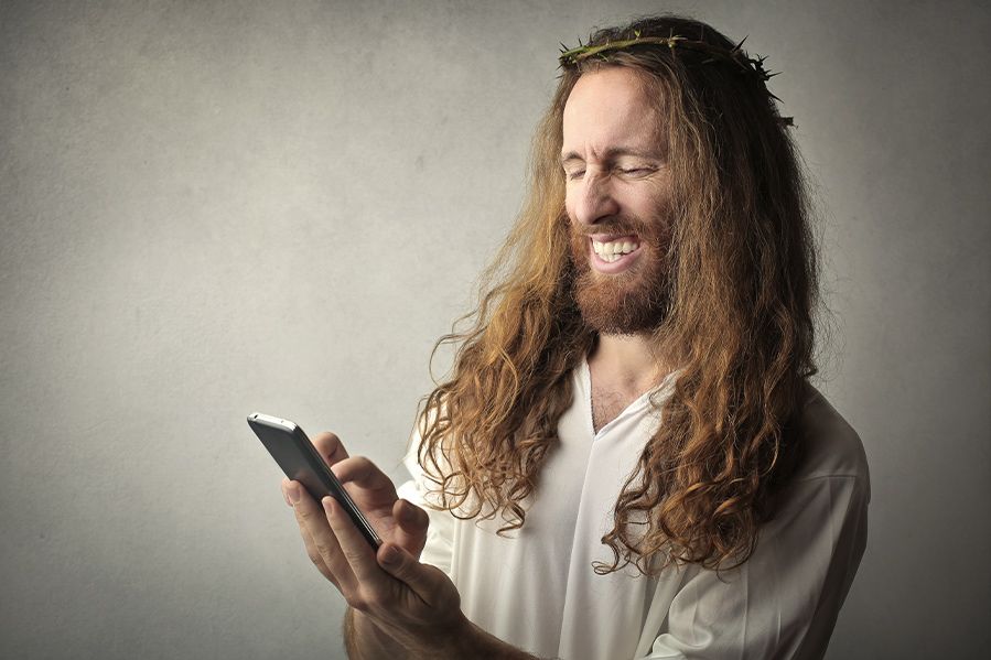 jesus scrolling on his phone while laughing