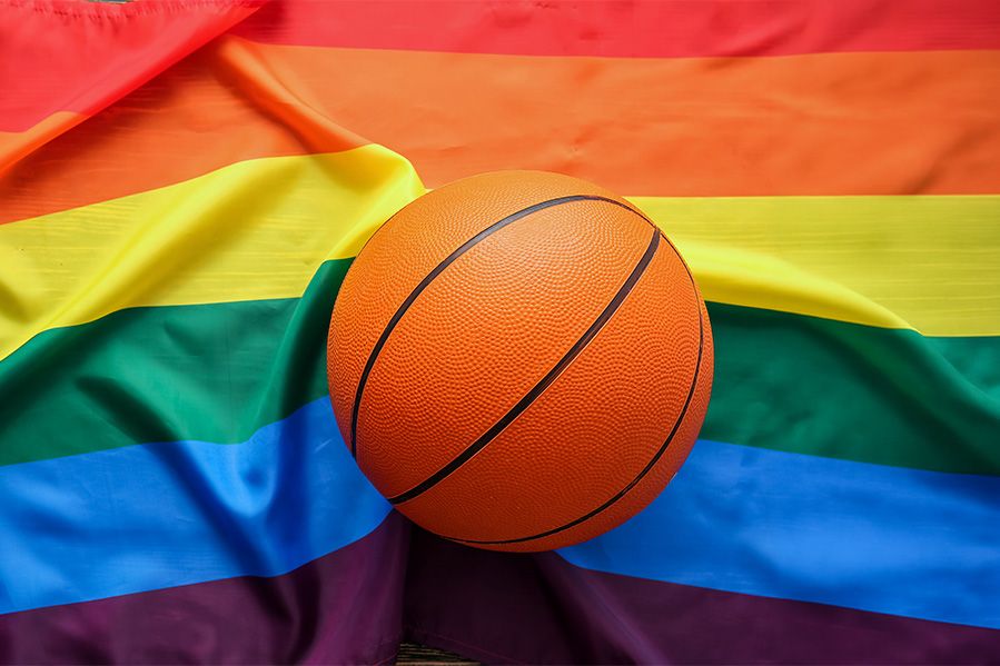 basketball resting on top of lgbt pride flag
