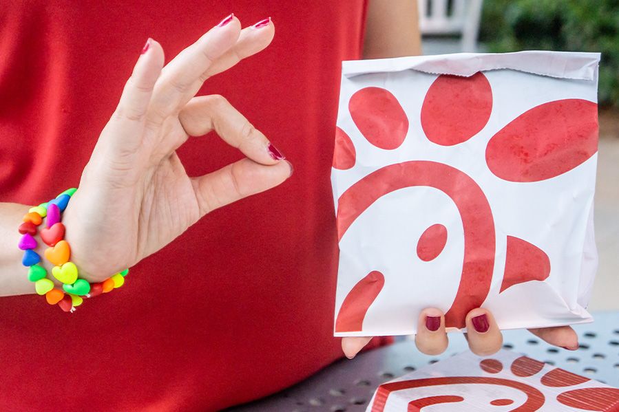 lgbt activist giving a-ok sign with chick-fil-a bag