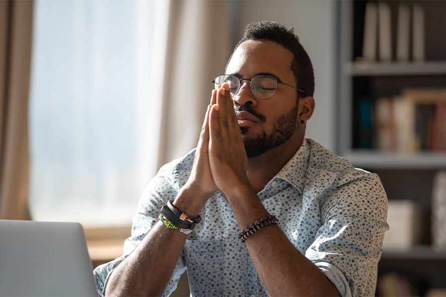 man at work praying at desk