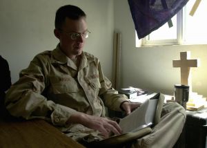 Military chaplain in army fatigues reading bible