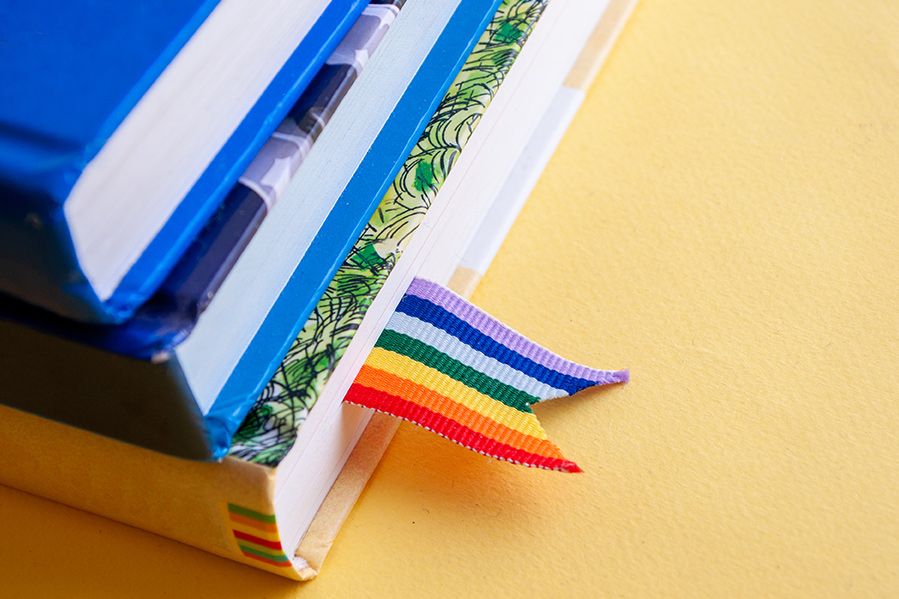 stack of books with rainbow bookmark