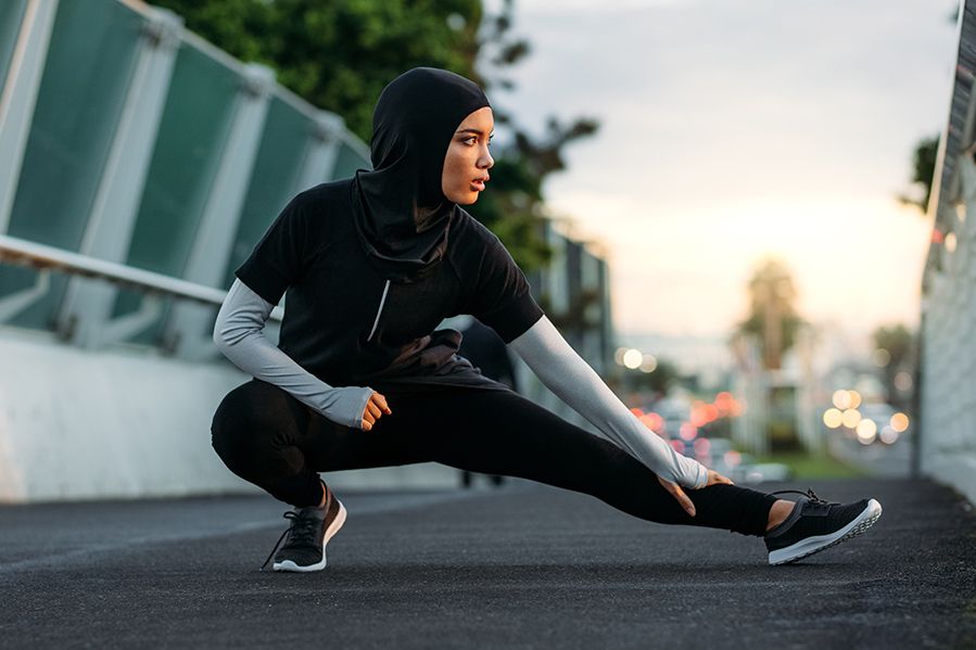 Muslim athlete stretching before training