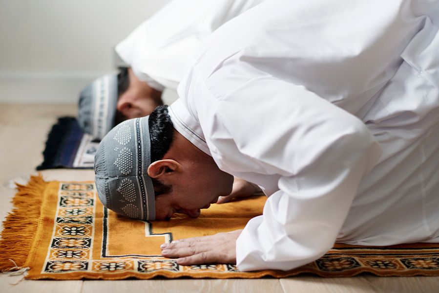 muslim men with heads bowed in prayer