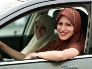 Muslim woman in hijab driving car