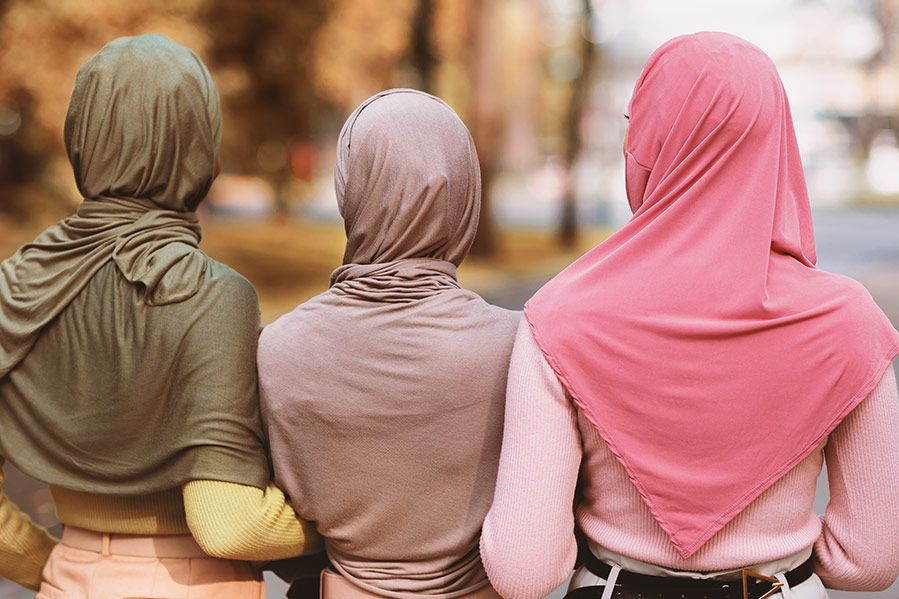 muslim women in hijab linked arm in arm