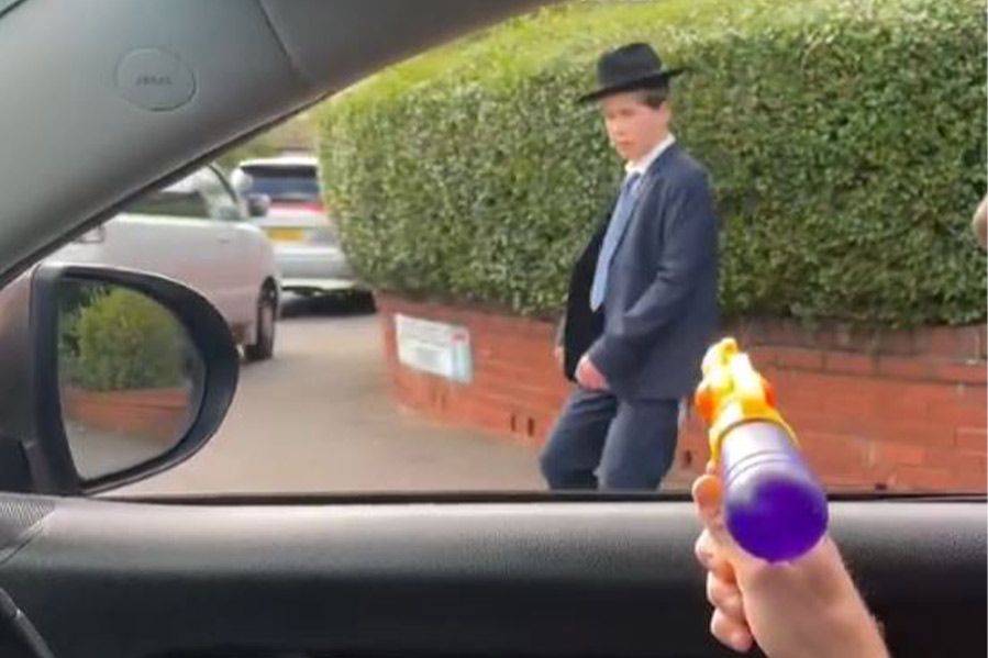 spraying orthodox man with water gun