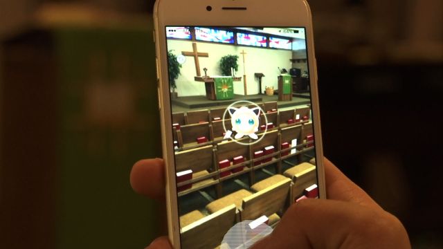 A person playing Pokemon Go in a church