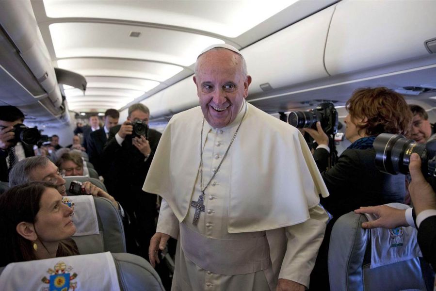 Pope Francis speaks with reporters on the papal plane. 