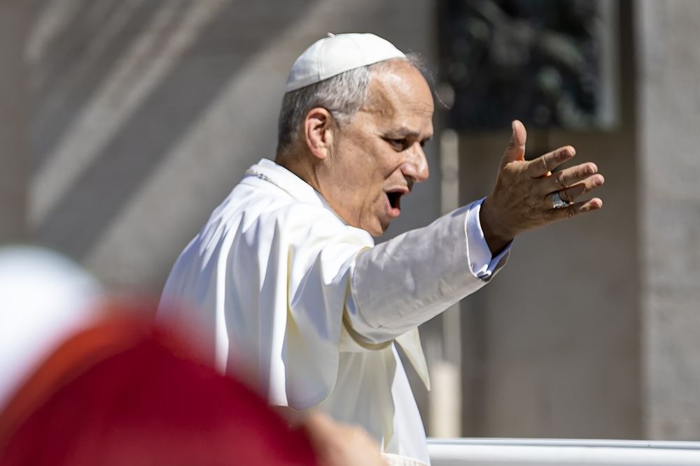 Pope Leo waves and speaks exuberantly to a crowd.