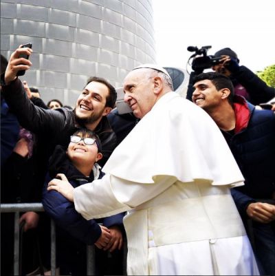 Pope Francis posing for a selfie with admirers.