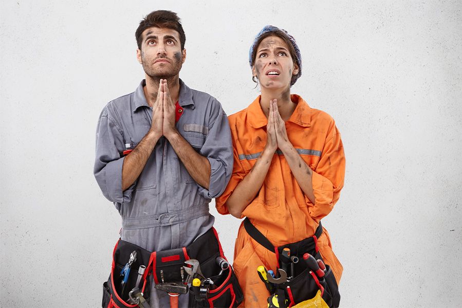 two dirty construction workers anxiously praying to god