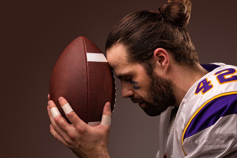 football player kneeling in prayer