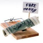 rolled up cash in mouse trap next to free money sign