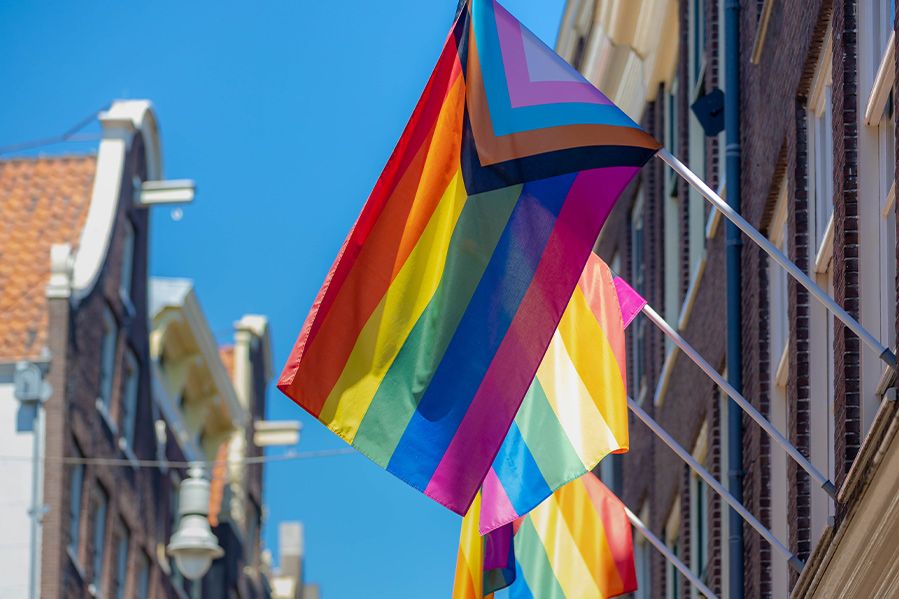 pride flag hanging on city street