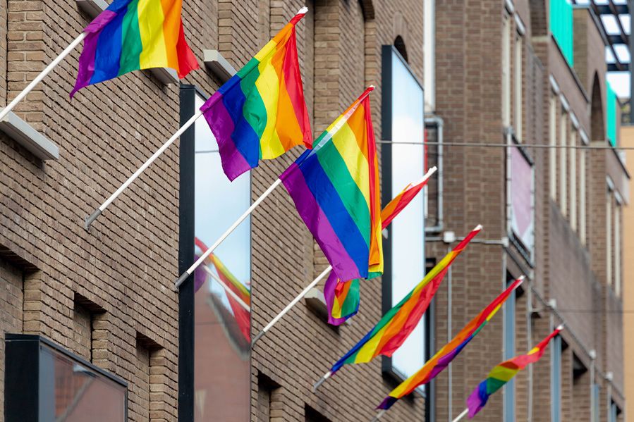 pride flags hanging from building flagpole