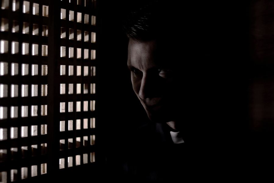 priest in dark confession booth