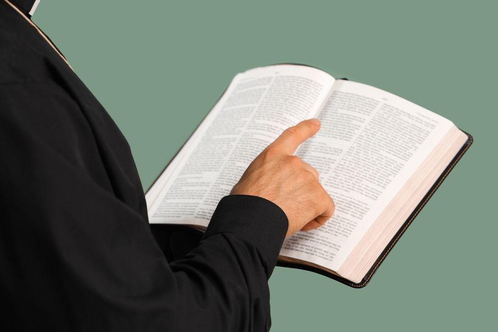priest reading from a bible