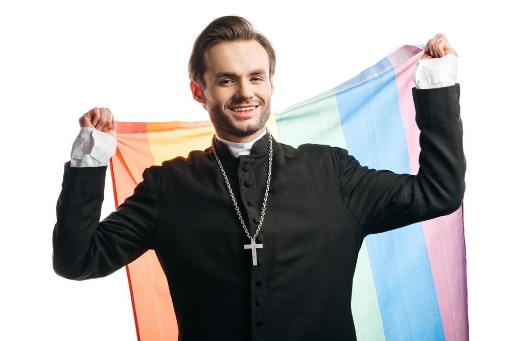 A pastor posing with a rainbow flag