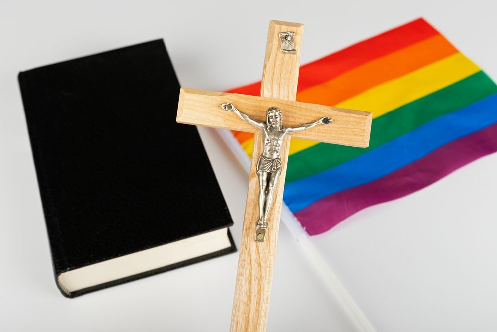 A Bible with a cross and a rainbow flag