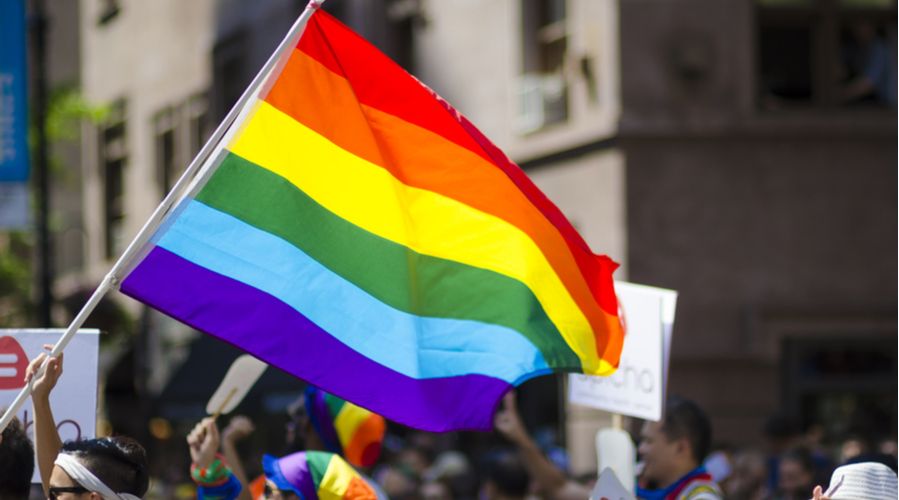 Person waving an LGBTQ rainbow flag