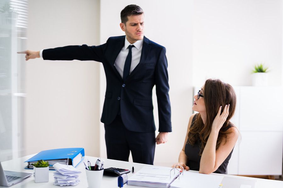 male coworker pointing at door telling woman to leave