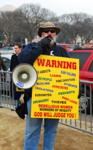 Christian protester holding sign and megaphone