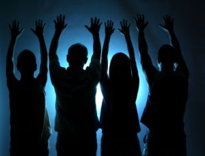 group with arms outstretched in praise of God