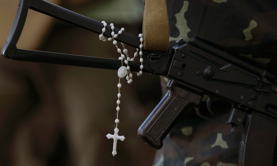 A rosary hanging around a gun.