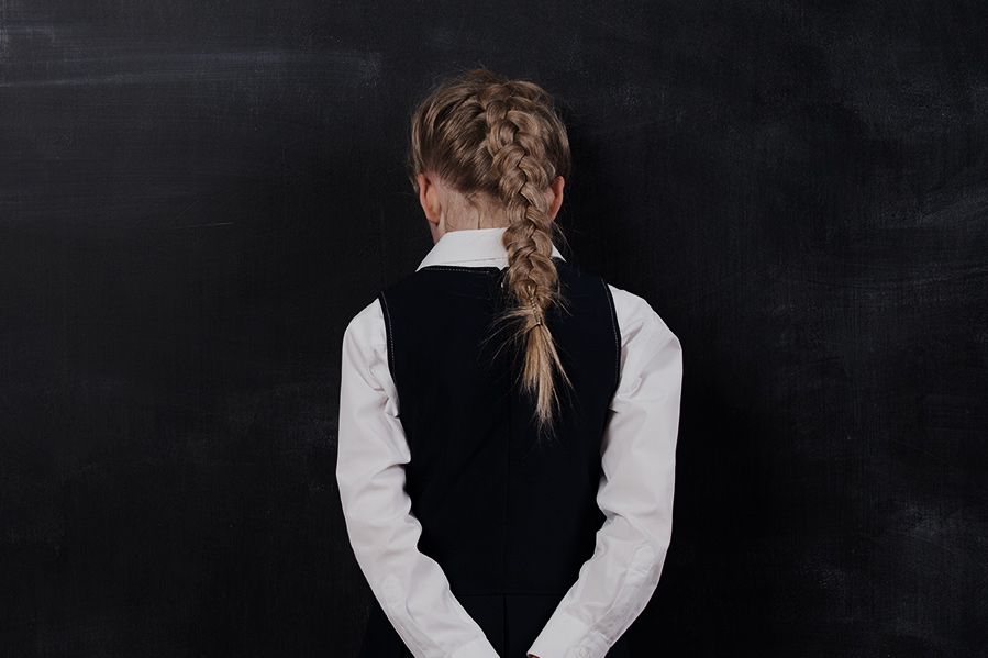 homeschooled child pressing face against blackboard