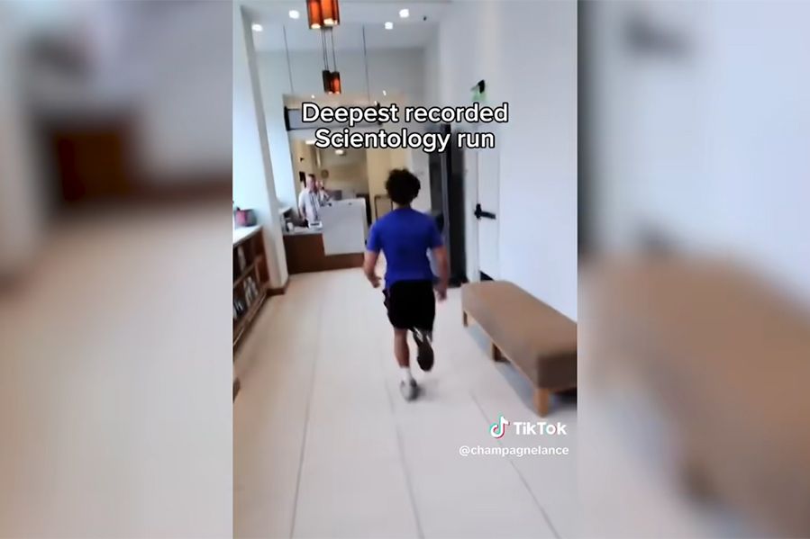 TikToker running down hallway in Scientology building in viral speedrunning trend