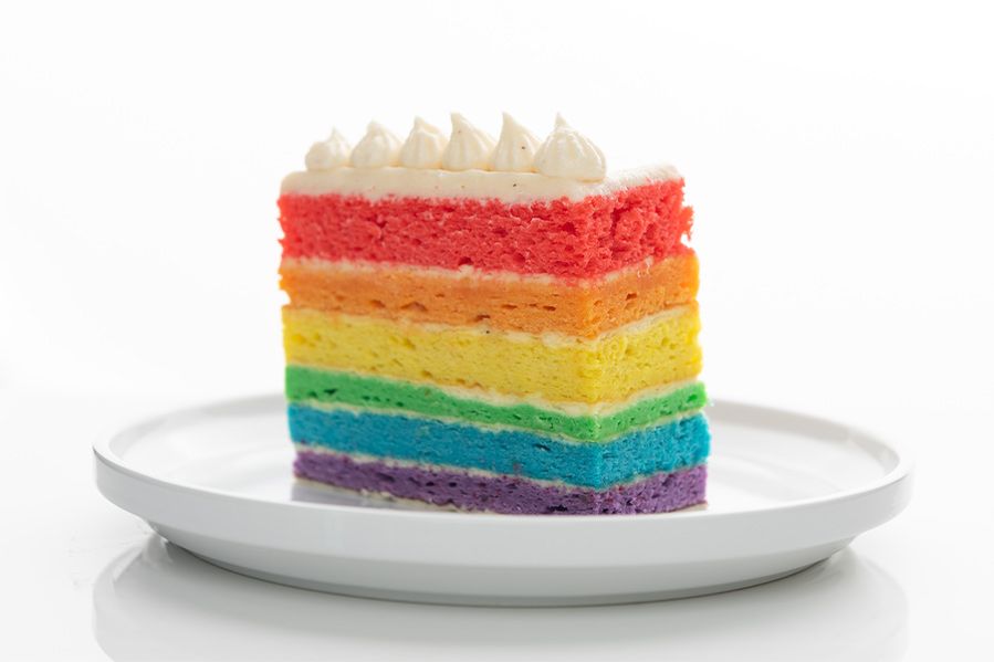 slice of rainbow wedding cake on plate