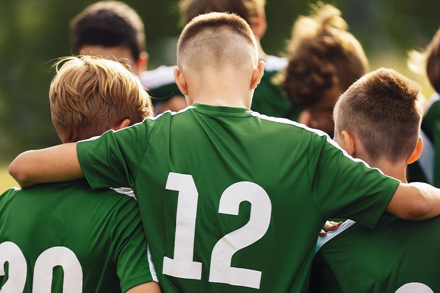 kids in soccer jerseys huddled in prayer