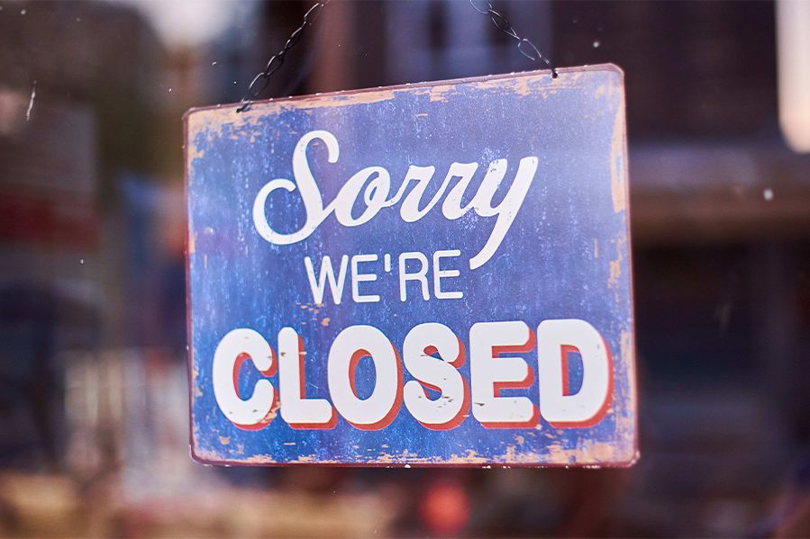 sorry we're closed sign hanging from window