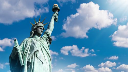 Close view of the Statue of Liberty against a blue sky.