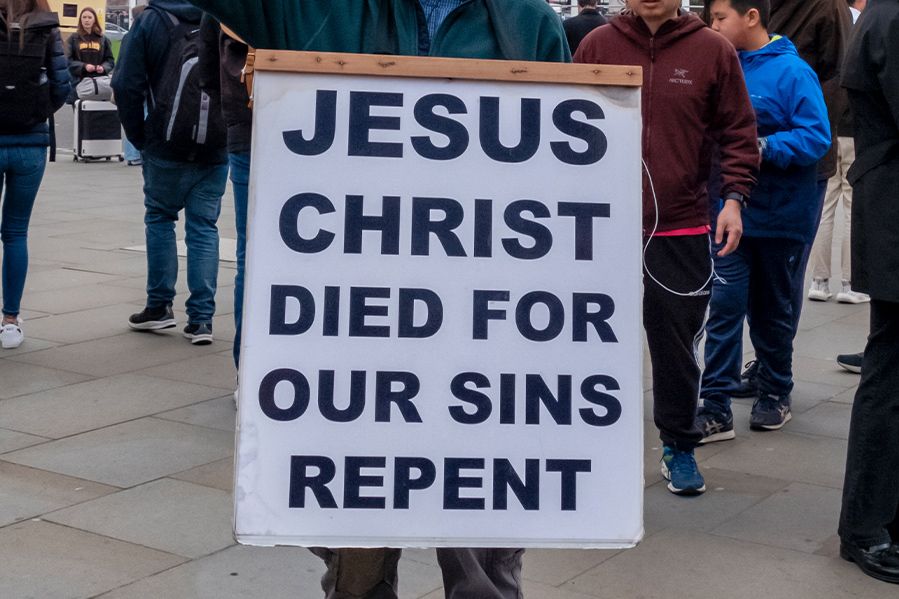 street preacher holding religious sign