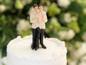 cake topper of two gay grooms