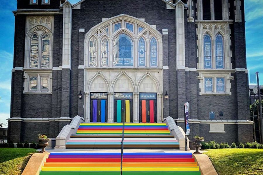 umc church with sidewalk and doors painted rainbow colors