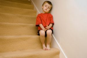 sad and abused child sitting on staircase
