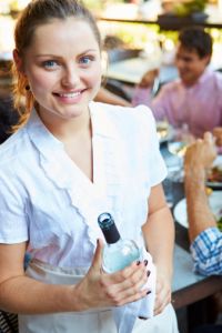 A waitress wearing jeans tying apron