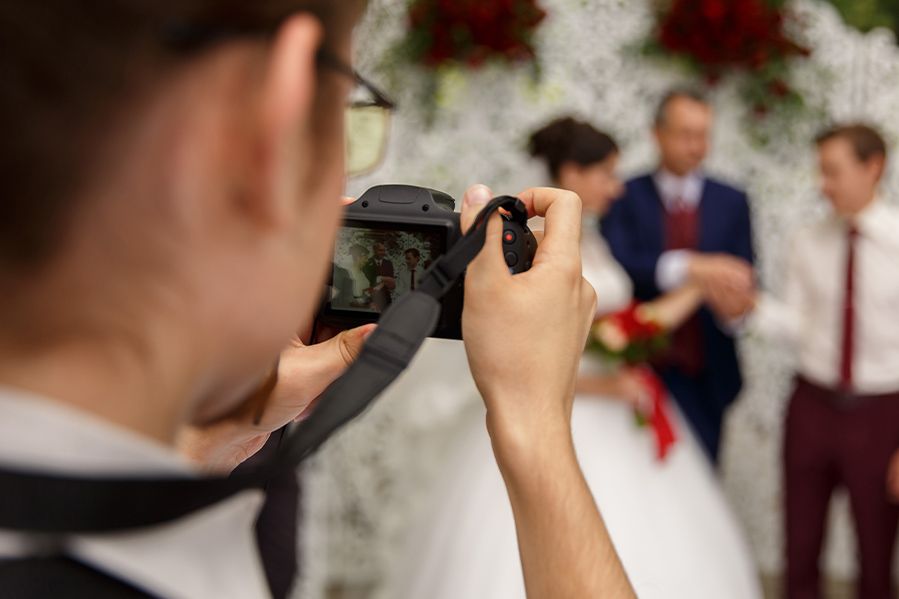 wedding photographer taking photo of bride and groom at wedding